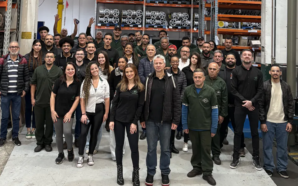 Equipe da BVI reunida no galpão, entre as estantes de válvulas